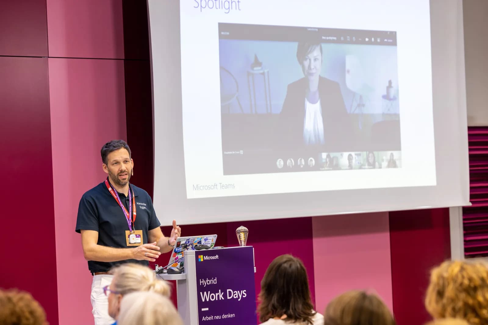 Alexander Eggers spricht auf der Bühne der Microsoft Hybrid Work Days vor Publikum, im Hintergrund eine Folie zu Microsoft Teams
